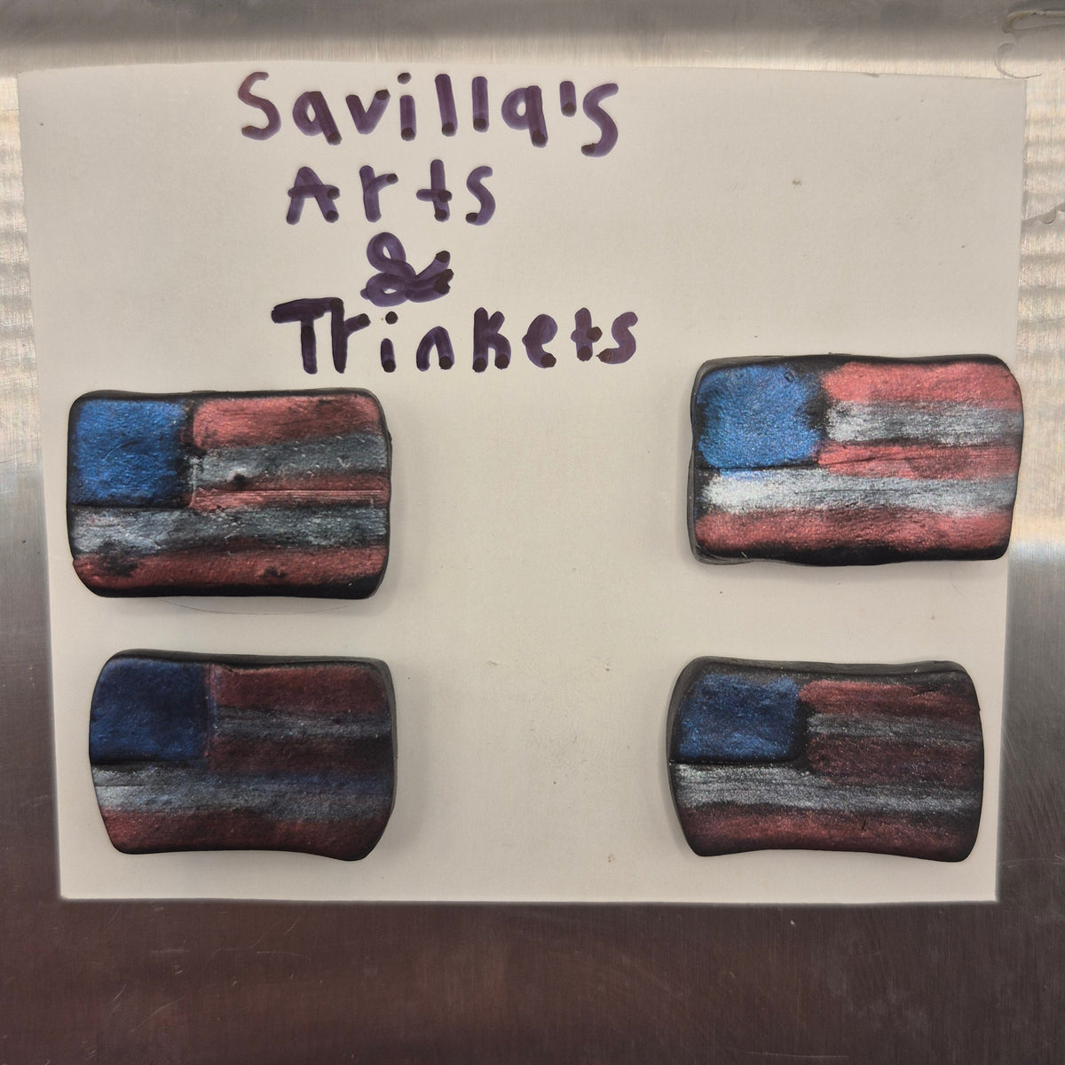 Four rectangular earrings with a distressed American flag design in red, white, and blue, displayed on a white card labeled 'Savillq's Arts & Trinkets' against a metallic background.
